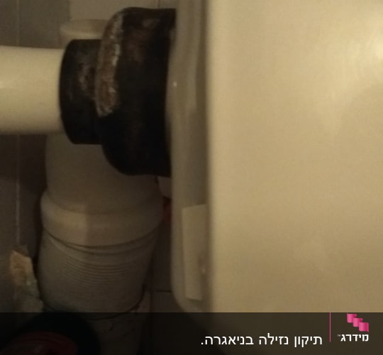 צינור ביוב מחובר לאסלה בחדר אמבטיה